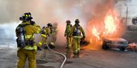 Many fluids are flowing in this scene. Water from the hose and smoke from the fire are visible flows. Less visible are the flow of air and the flow of fluids on the ground and within the people fighting the fire. Explore all types of flow, such as visible, implied, turbulent, laminar, and so on, present in this scene.