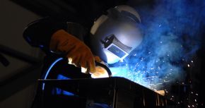 The welder’s gloves and helmet protect him from the electric arc that transfers enough thermal energy to melt the rod, spray sparks, and burn the retina of an unprotected eye. The thermal energy can be felt on exposed skin a few meters away, and its light can be seen for kilometers.
