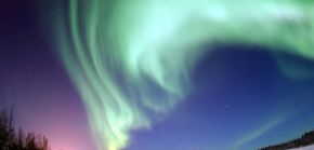 The magnificent spectacle of the Aurora Borealis, or northern lights, glows in the northern sky above Bear Lake near Eielson Air Force Base, Alaska. Shaped by the Earth’s magnetic field, this light is produced by radiation spewed from solar storms.